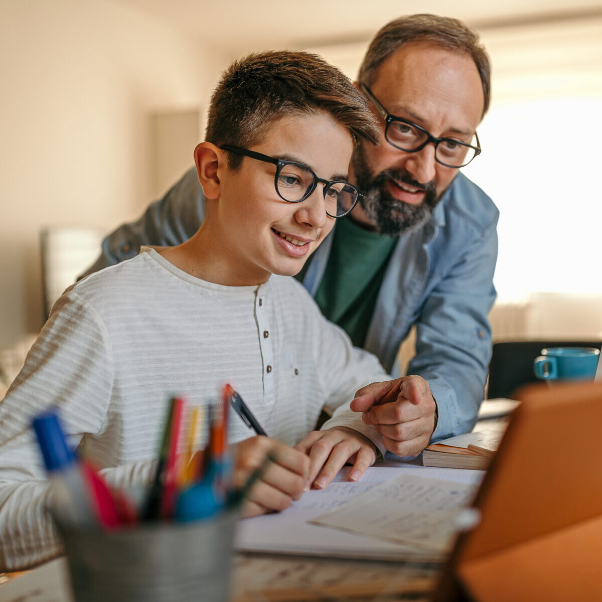 Happy father helping son with homework