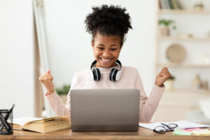 Excited Girl At Laptop Gesturing Yes Getting A-Grade At Home Excited Black Girl At Laptop Gesturing Yes.