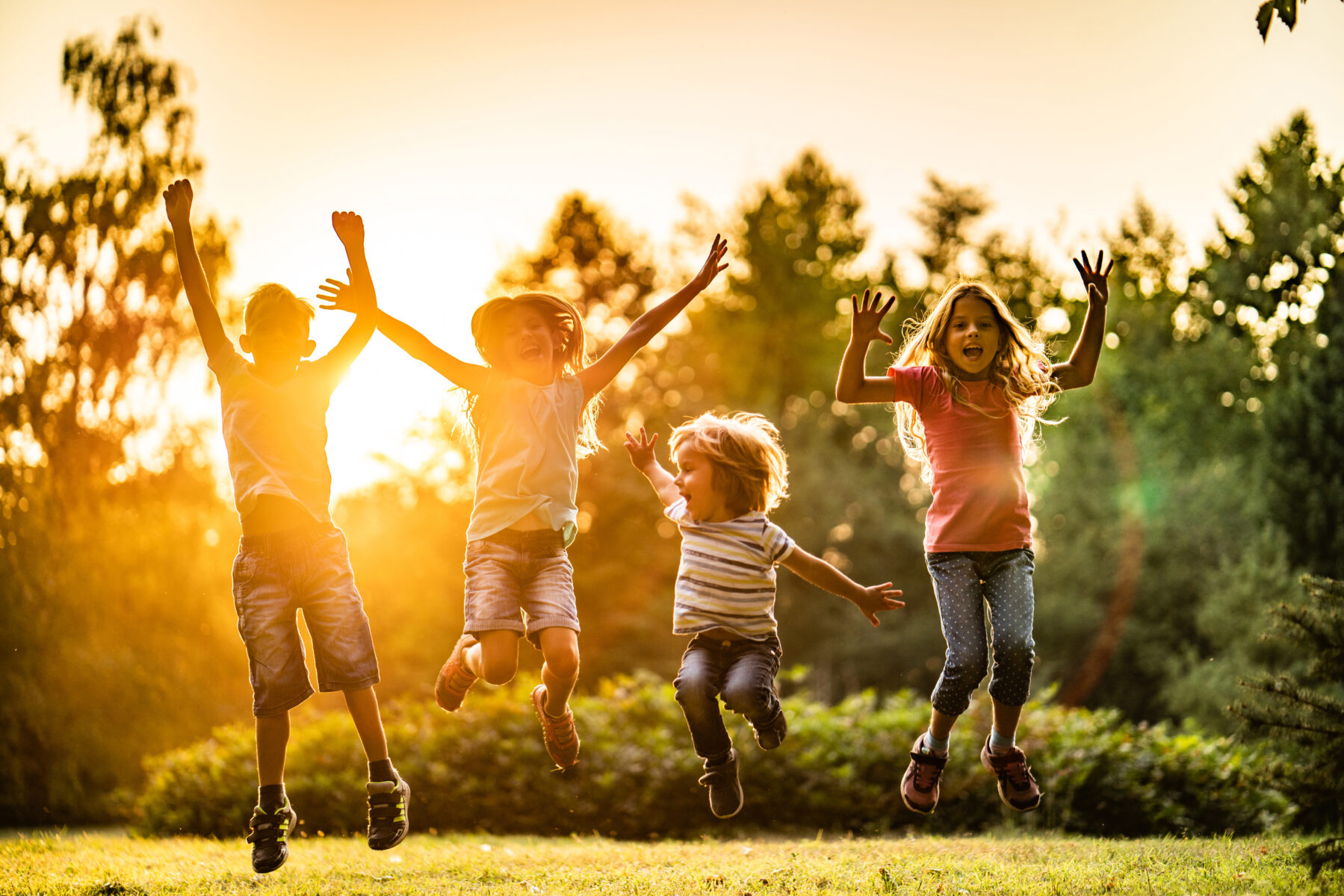 Children jumping at sunset