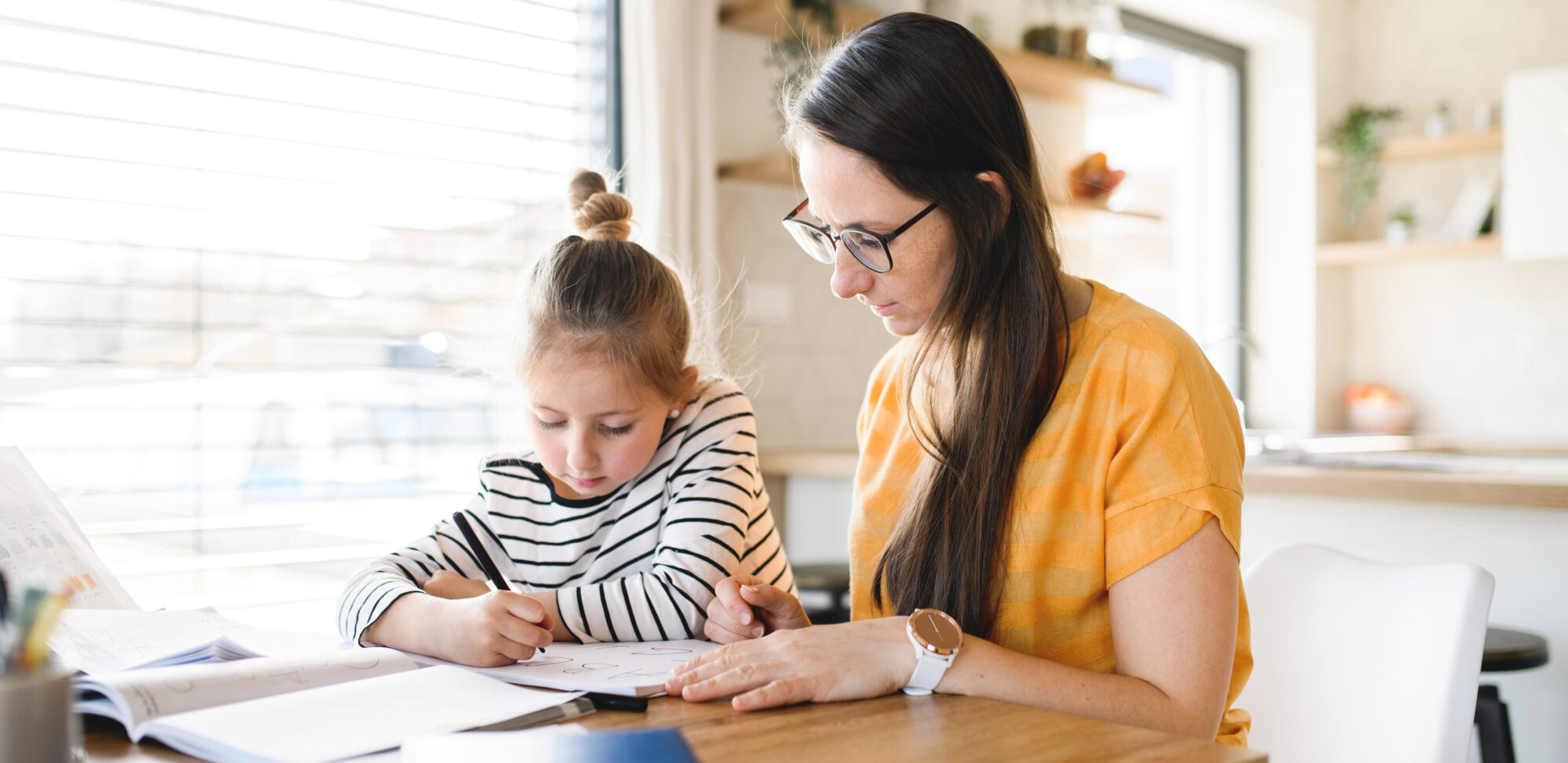 Mother and daughter learning indoors at home, Corona virus and quarantine concept.